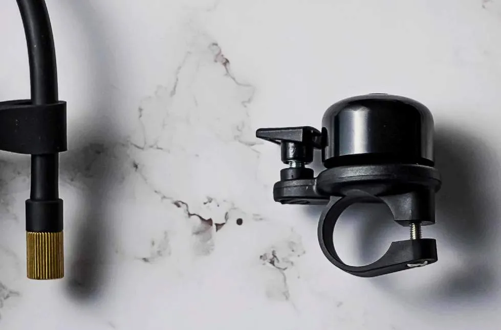 A bicycle bell opened to reveal an Apple AirTag hidden inside.