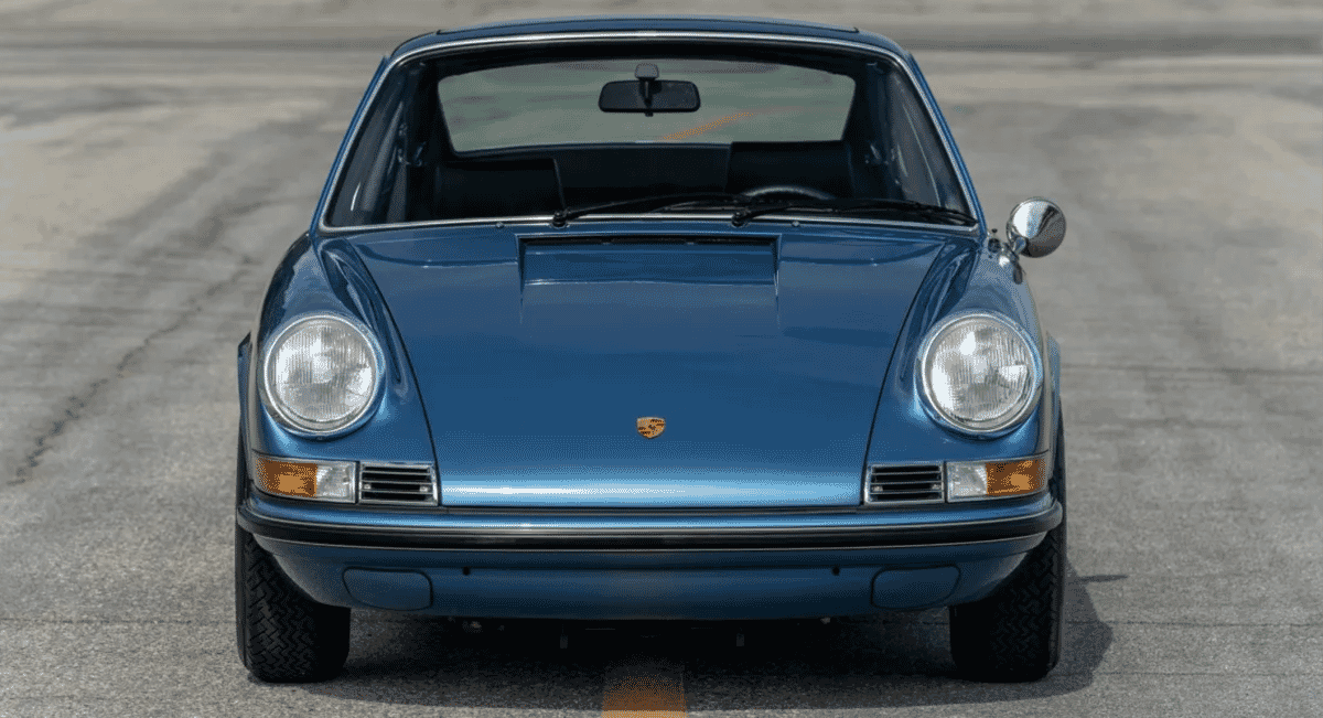 Front-facing view of a Gemini Blue Porsche 911 highlighting its round headlights.