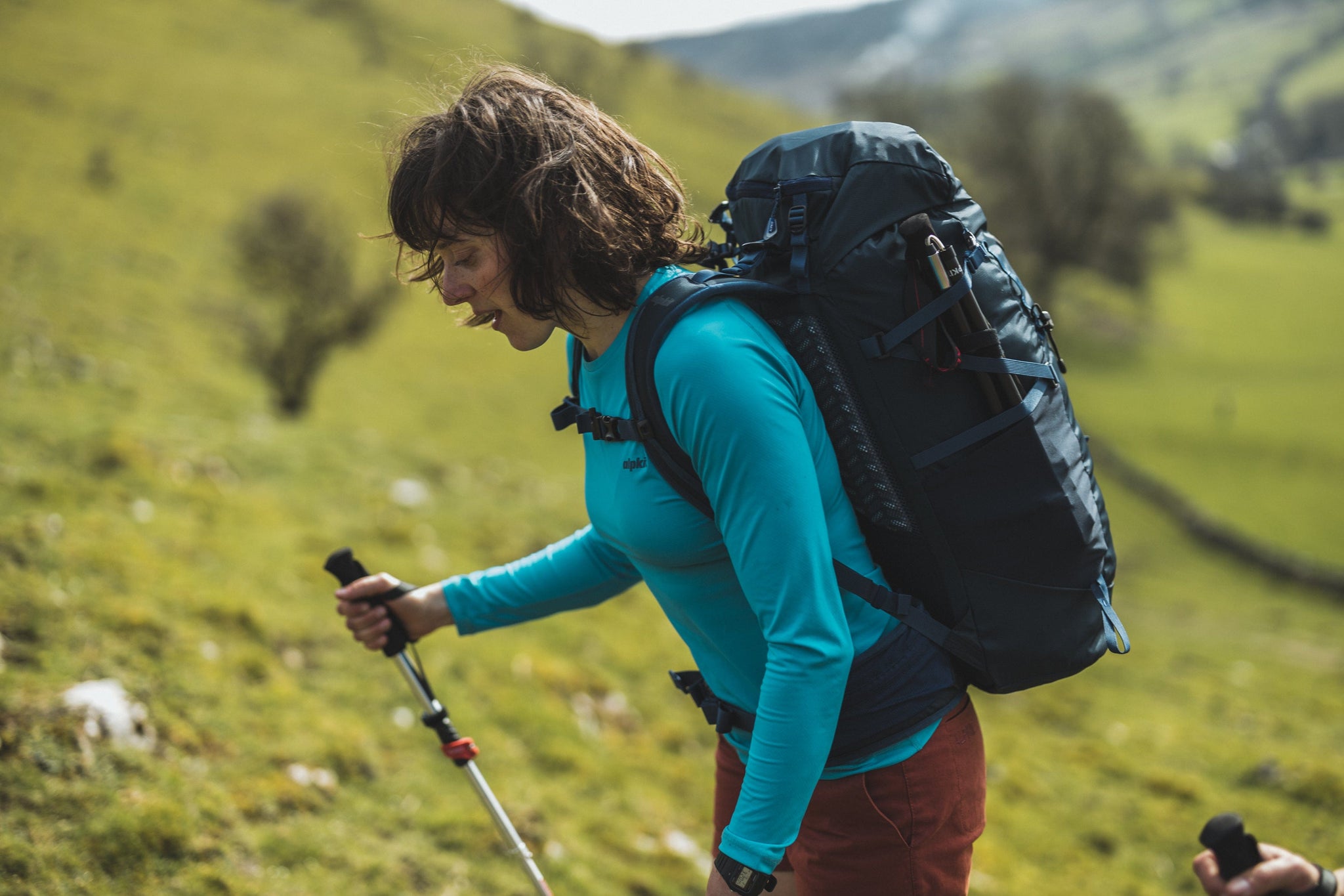 A hiker wearing a Vayper ultralight wicking breathable base layer on a sunny trail.