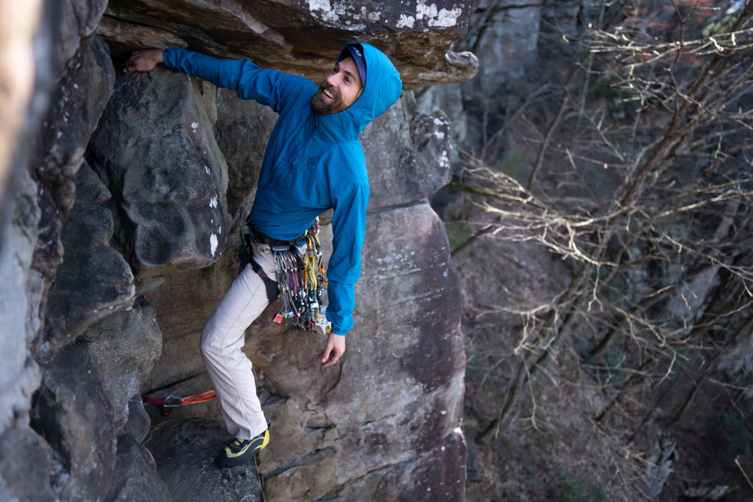 A rock climber wearing a Black Diamond Alpine Start windshell while scaling a granite wall.