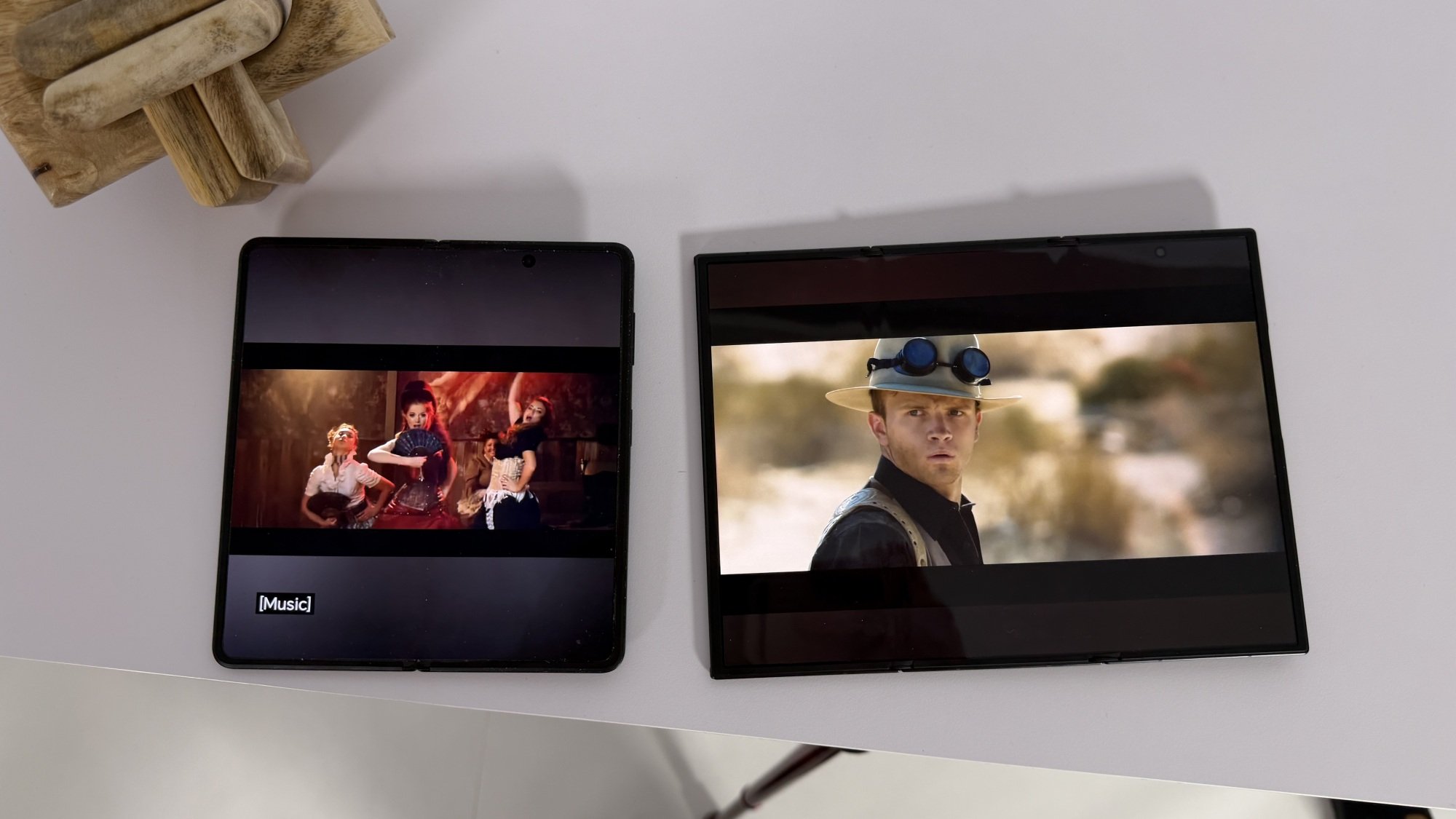 Two Samsung Galaxy Z TriFold units, one fully unfolded to a flat tablet and one partially folded in a Z-shape.