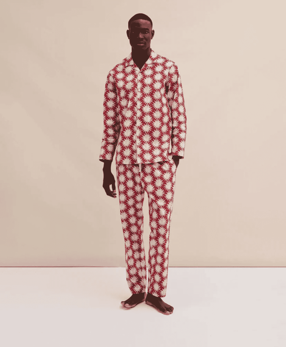 A man wearing a bold red and white starburst-patterned pajama set with long sleeves.