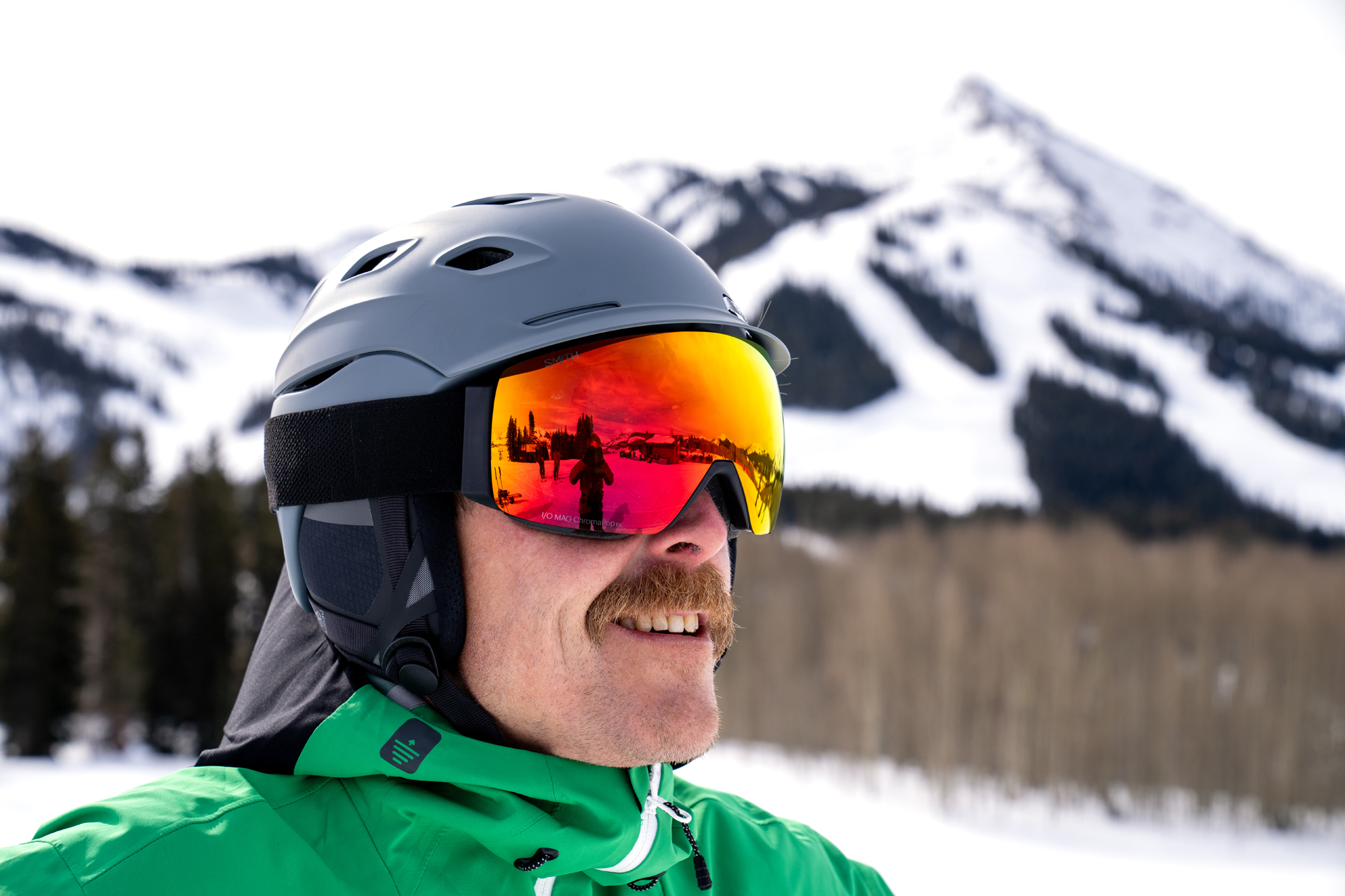 A person wearing Smith snow goggles while skiing on a sunny day.