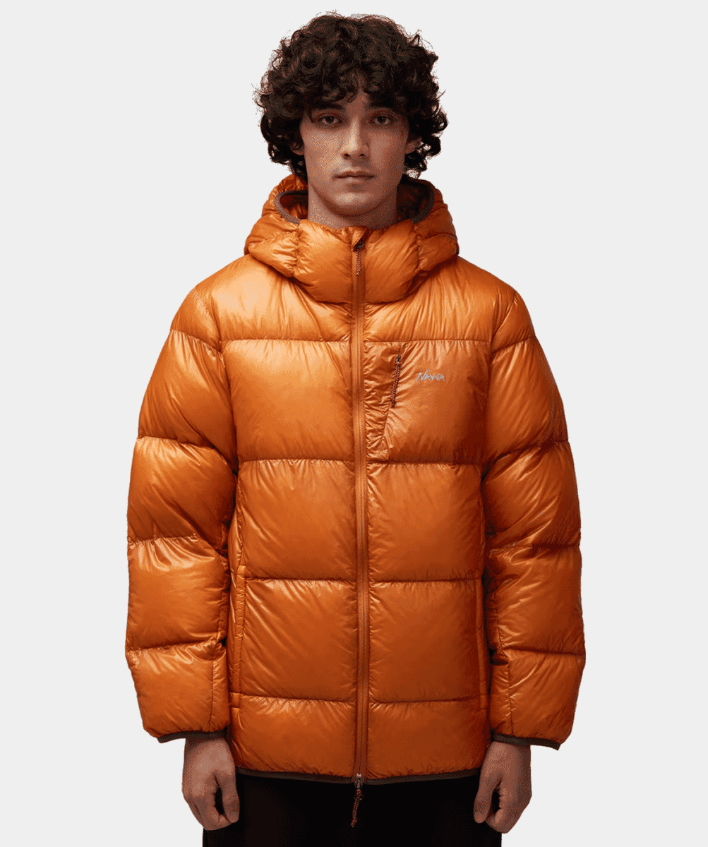 Man wearing a vibrant orange hooded puffer jacket with a subtle brand logo.