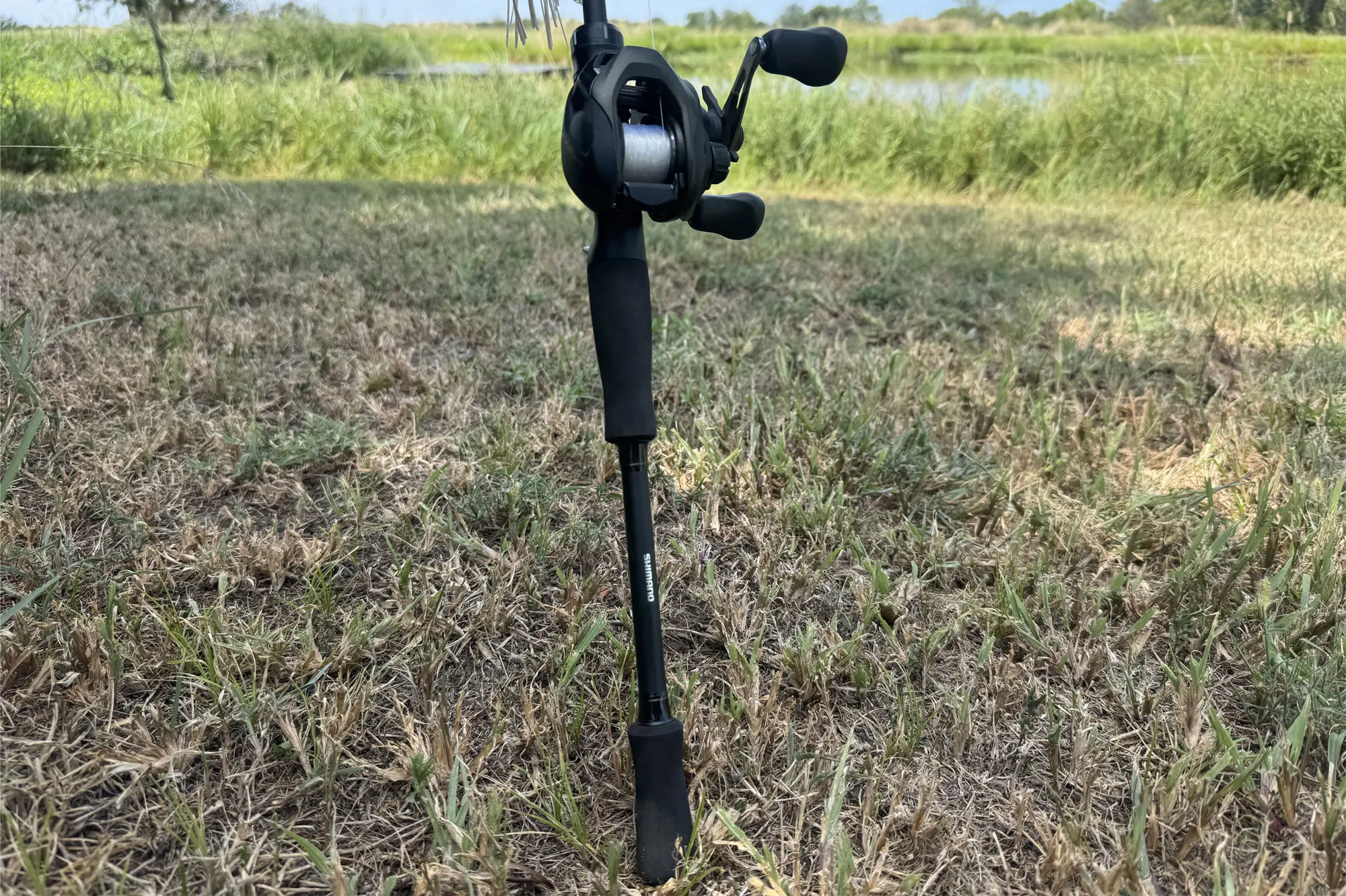 Close-up detail of the Shimano Caius baitcasting reel and rod handle.