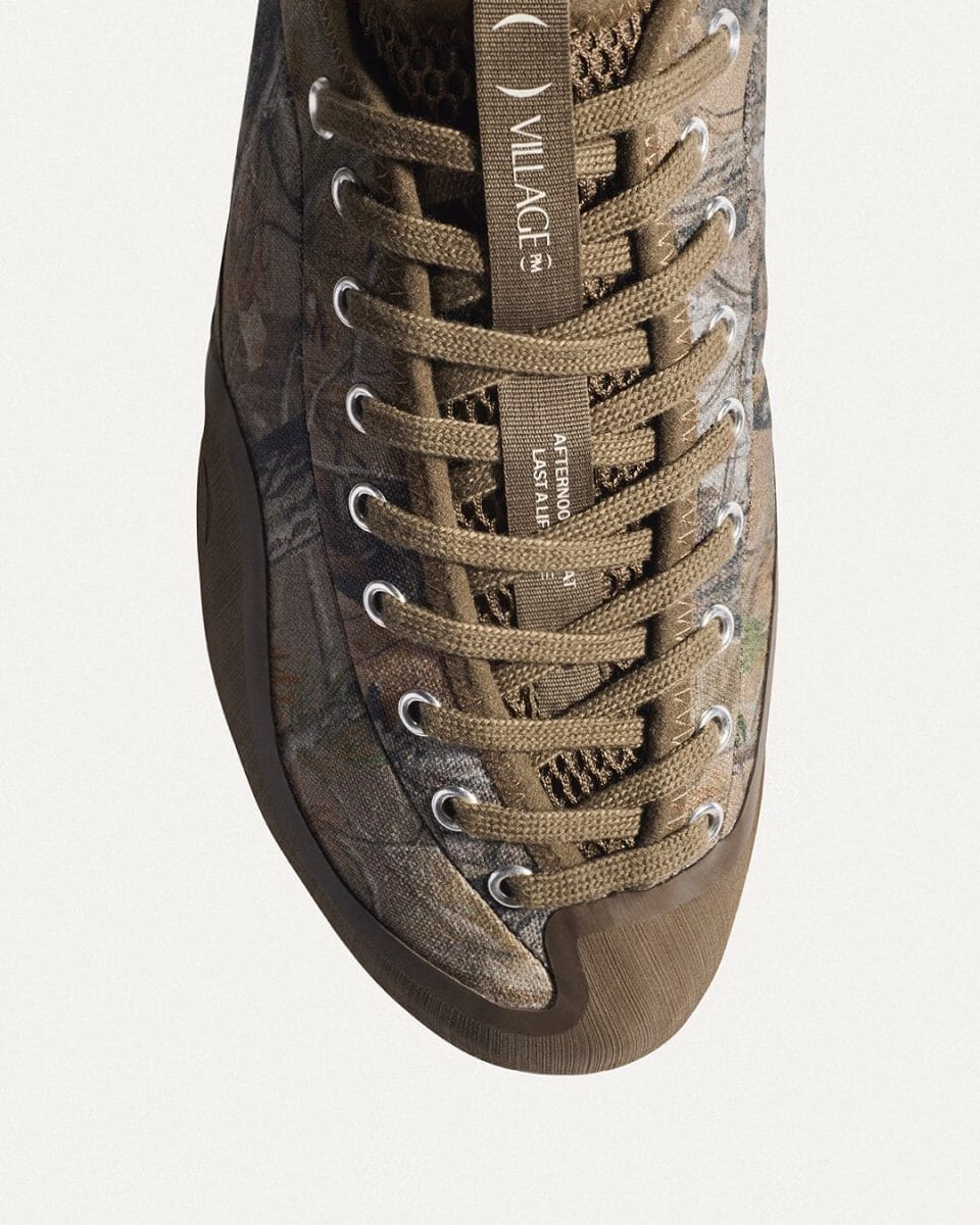 Detailed close-up of a camouflage patterned sneaker with branded tongue tags.
