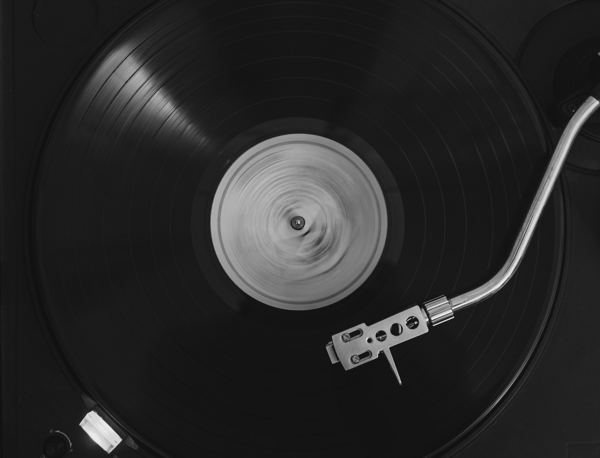 A vintage record player sitting next to a modern soundbar on a wooden console.