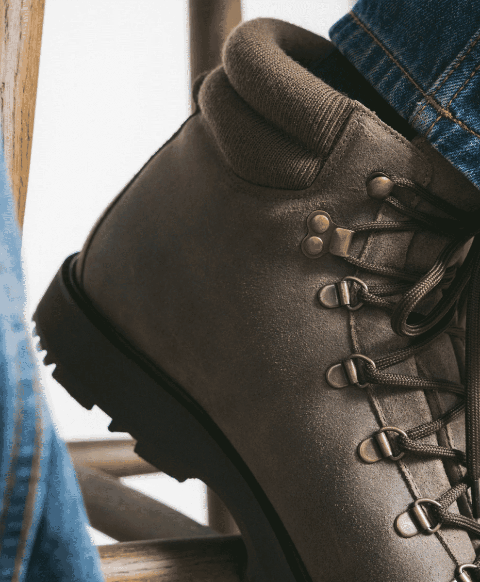 Close-up of Myrqvist brown suede boots with blue denim jeans.