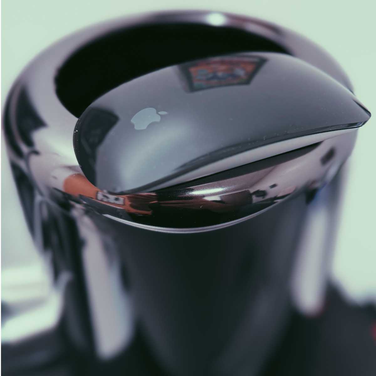 An Apple Magic Mouse placed next to a high-end Mac Pro setup