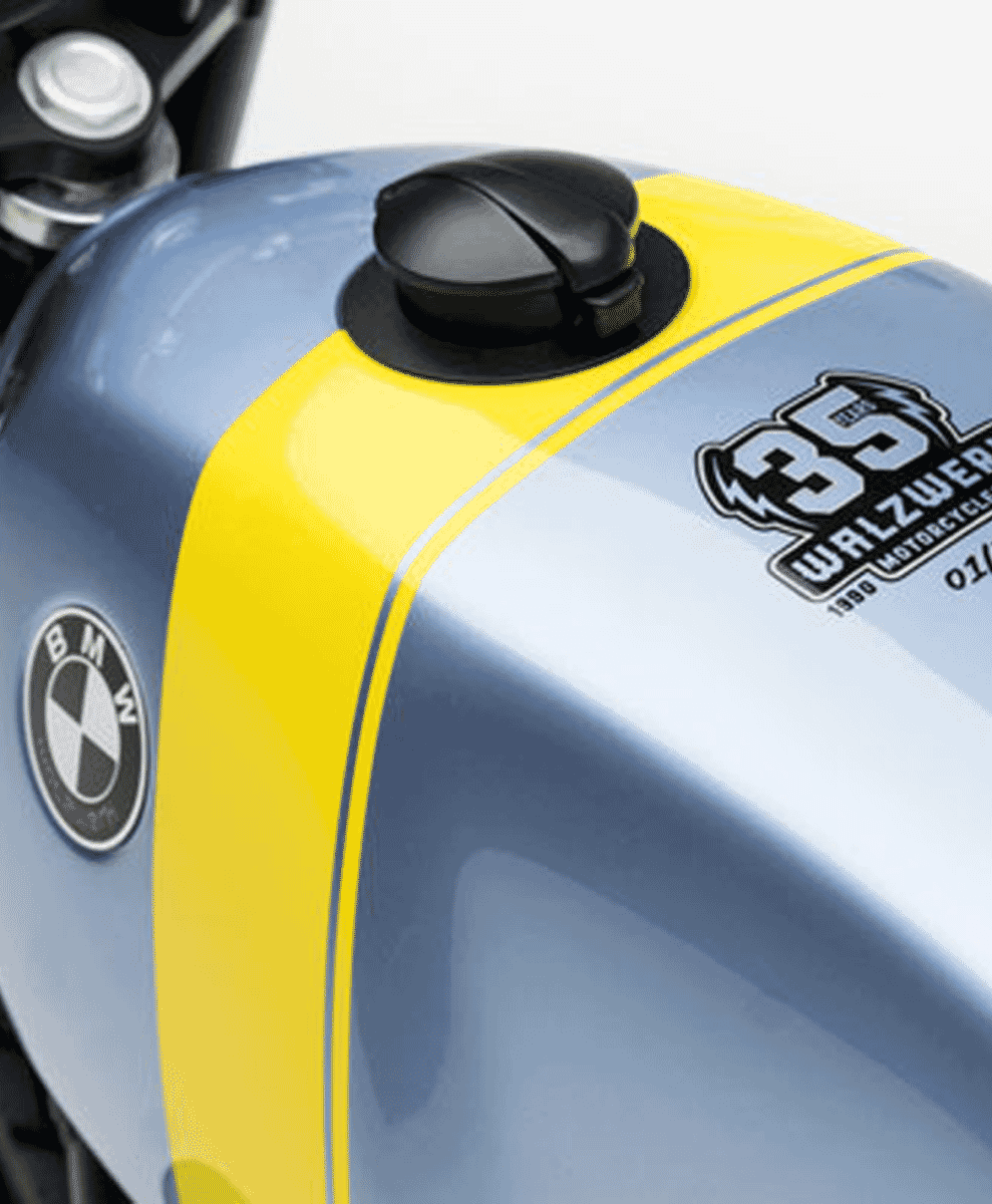 Close-up of the light blue fuel tank with yellow racing stripes and WalzWerk anniversary branding.
