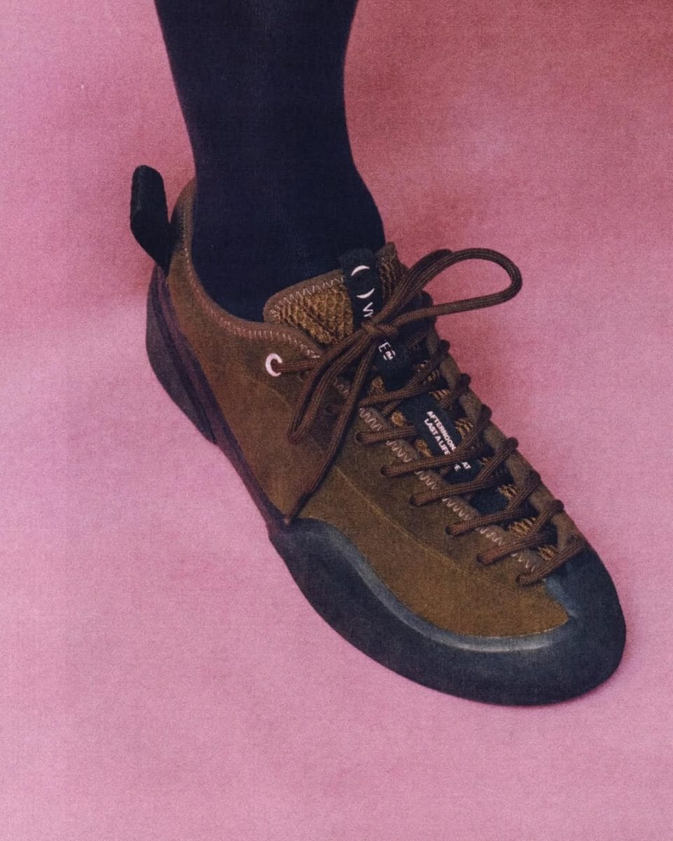 Close-up of a brown suede climbing shoe paired with black socks.