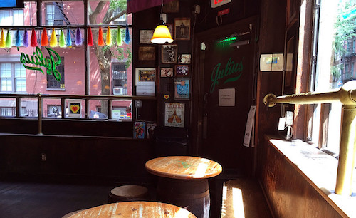 The vintage corner exterior of Julius' Bar with its classic wooden window frames and signage.