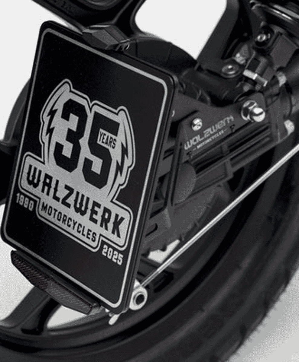 Monochrome close-up of the custom 1890–2025 anniversary rear plate on the motorcycle.