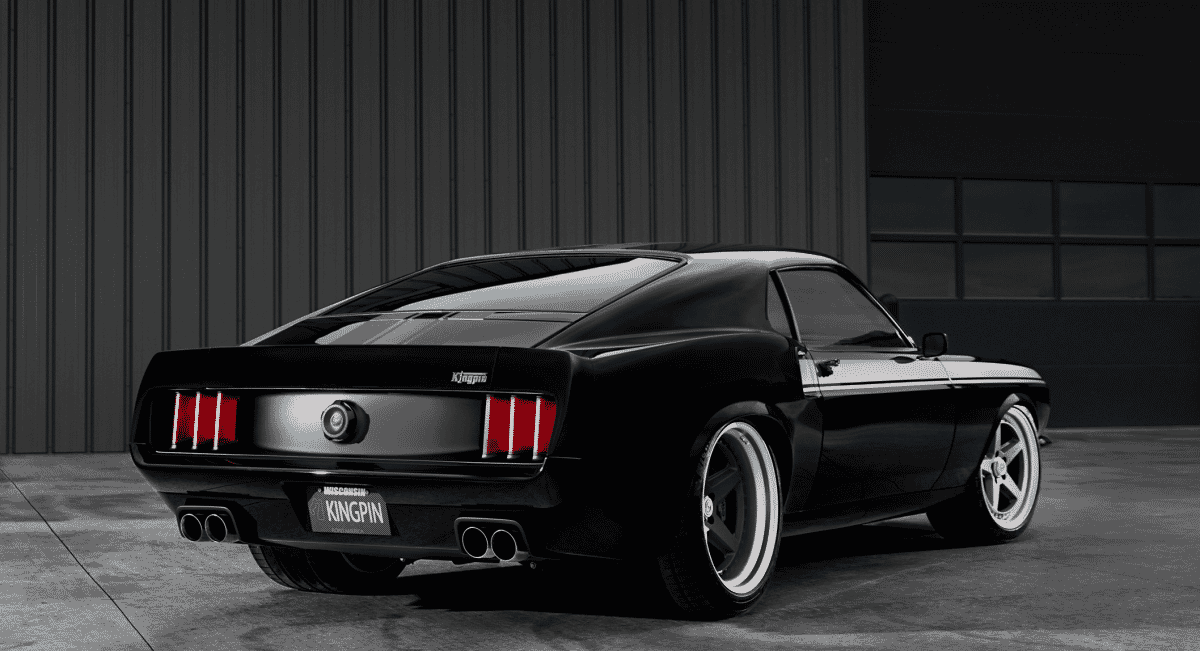 The black Kingpin Mustang parked in a dimly lit industrial garage setting.