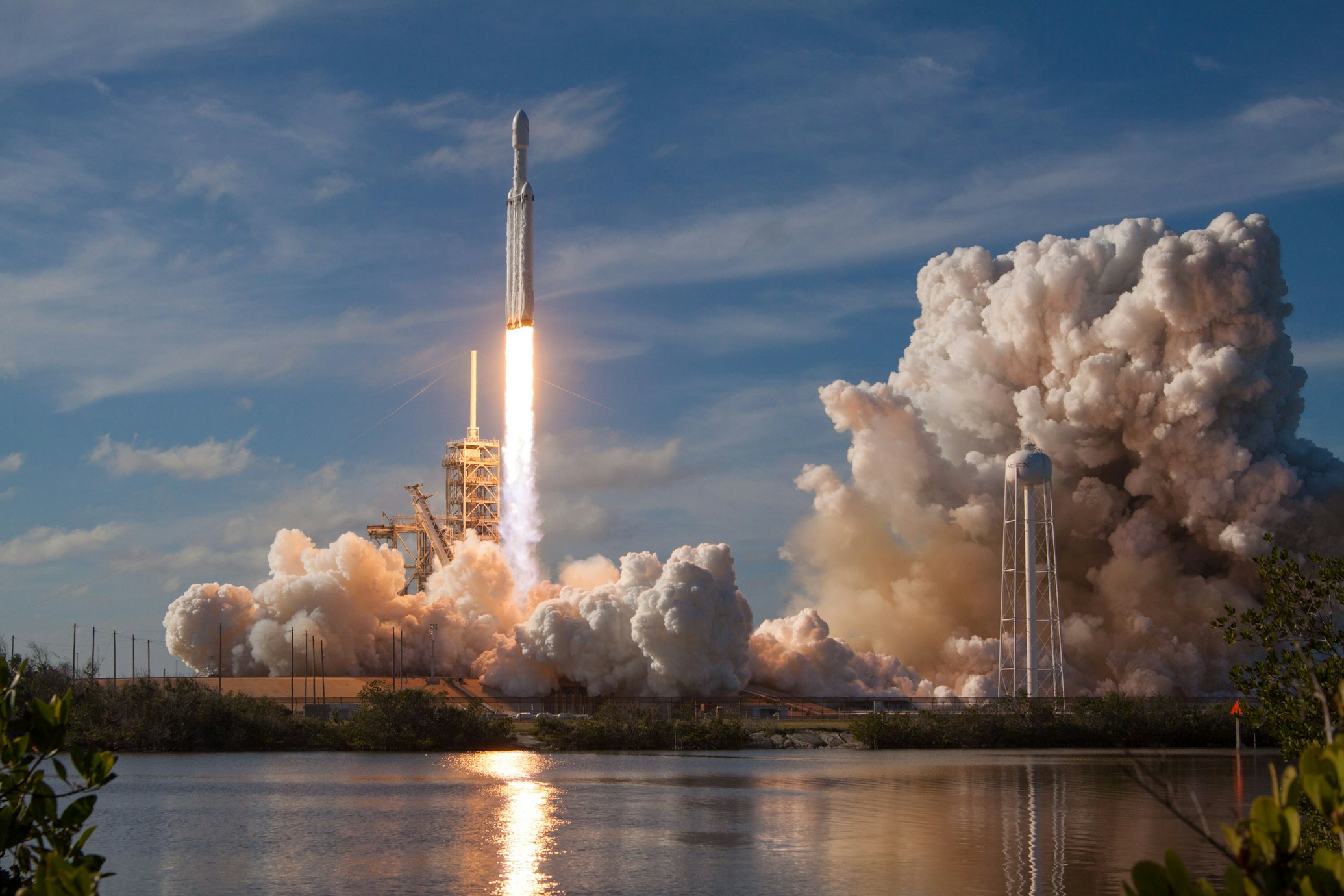 A SpaceX Falcon 9 booster standing vertically at a launch pad during golden hour.
