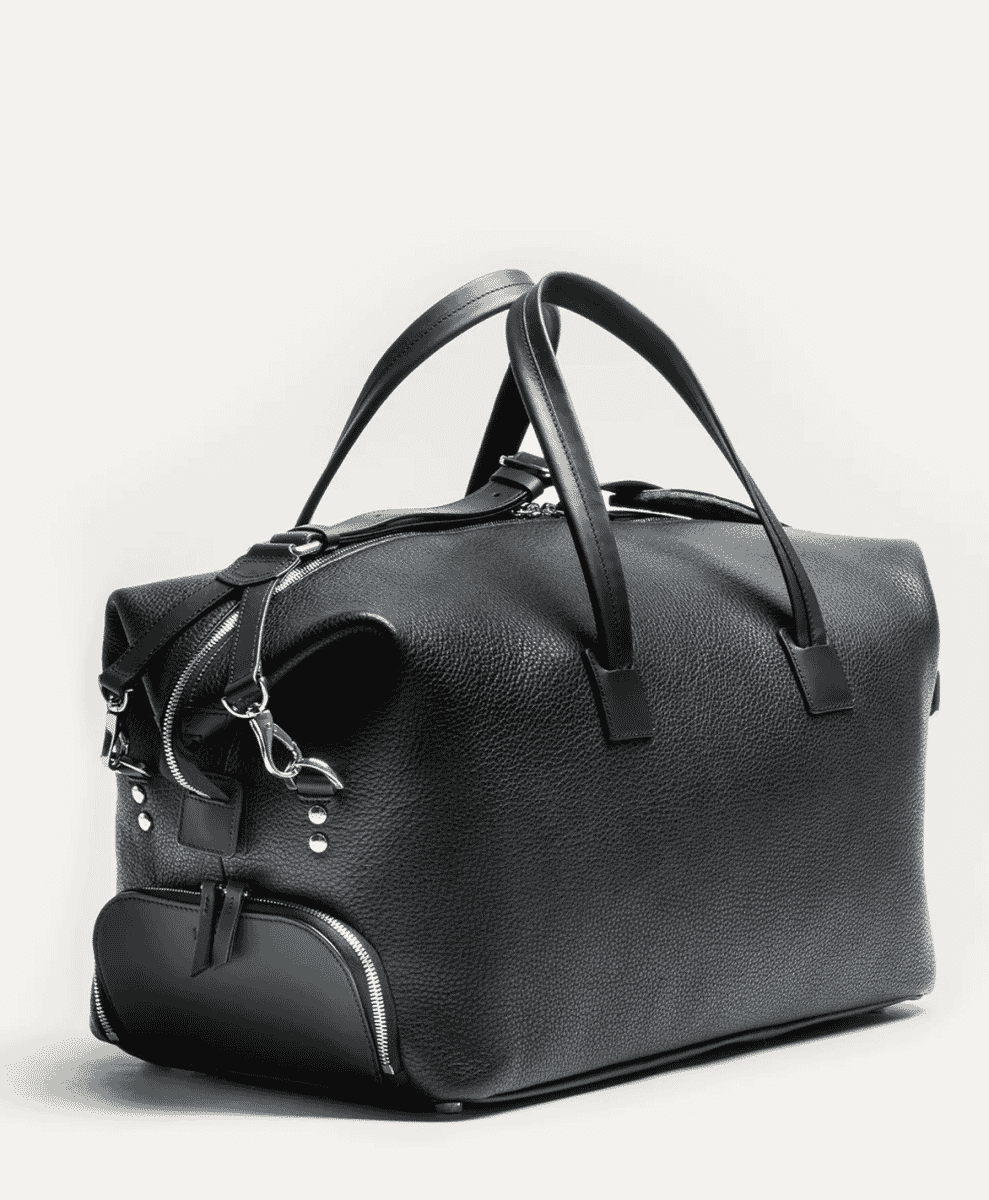 A sleek black textured leather duffel bag with silver hardware.