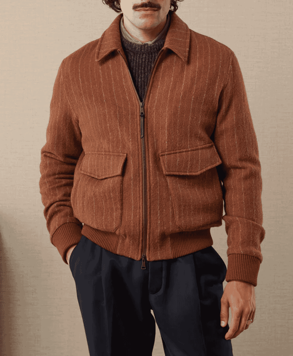 Man modeling a brown pinstripe wool bomber jacket layered over a dark knit sweater.