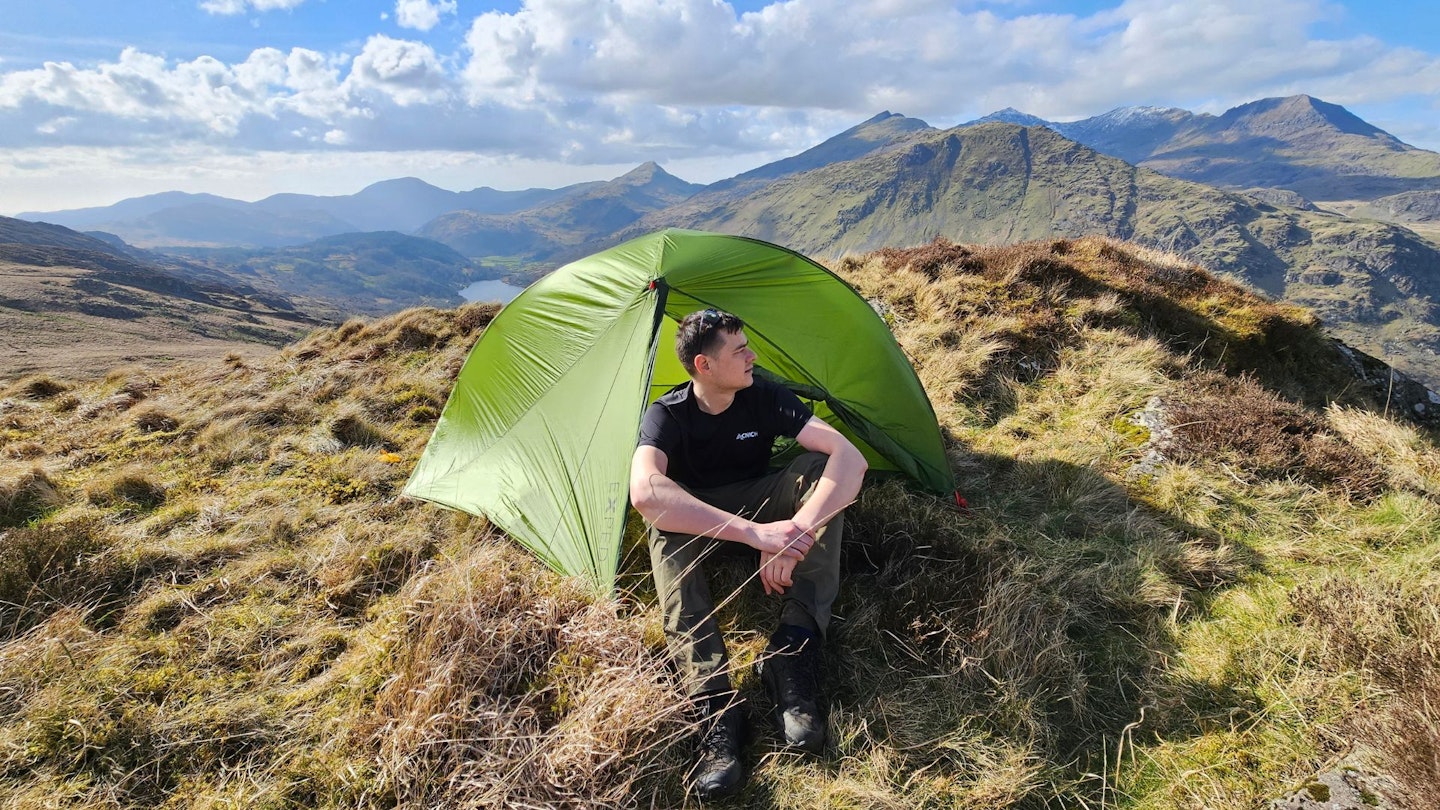 An Exped Mira 1 HL lightweight tent pitched in a mountain landscape.
